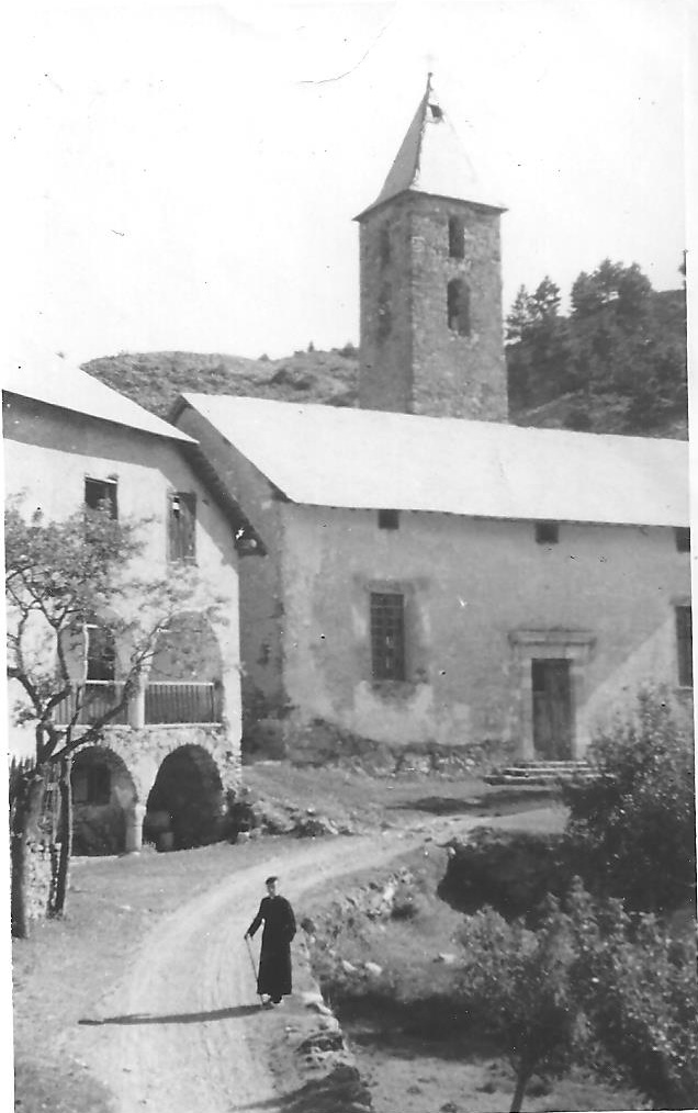 Réotier 1943. L’abbé Clerc devant la Cure et l’Eglise St Michel bien mal en point. Le seul hameau « tertiaire » de la commune à cette époque.(Ph. M.Blanc)